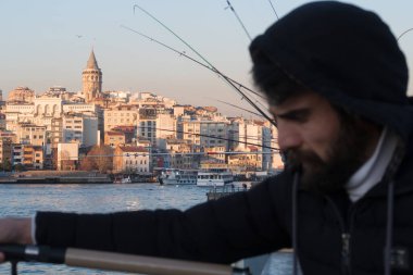 İstanbul, Türkiye - 10 Ocak 2020: Galata Köprüsü 'ndeki balıkçılar, Eminonu, Galata Köprüsü' nün arka planında yer alıyor. Türkiye