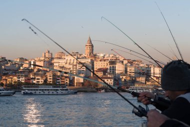 İstanbul, Türkiye - 10 Ocak 2020: Galata Köprüsü 'ndeki balıkçılar, Eminonu, Galata Köprüsü' nün arka planında yer alıyor. Türkiye