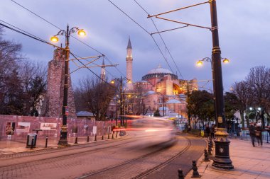 İstanbul, Türkiye - 9 Ocak 2020: İstanbul, Türkiye 'de akşam karanlığında Ayasofya müzesinden bir T1 tramvayı geçiyor