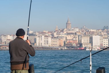 İstanbul, Türkiye - 10 Ocak 2020: İstanbul 'un Beyoğlu ilçesinde, Galata Köprüsü yakınlarındaki Eminonu ilçesinde, Golden Horn' da balıkçılar. Türkiye