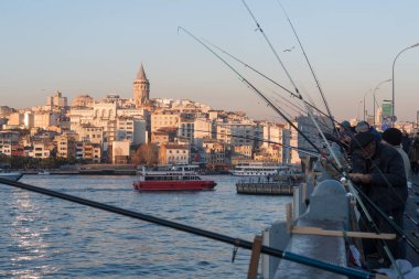 İstanbul, Türkiye - 10 Ocak 2020: Galata Köprüsü 'ndeki balıkçılar, Eminonu, Galata Köprüsü' nün arka planında yer alıyor. Türkiye