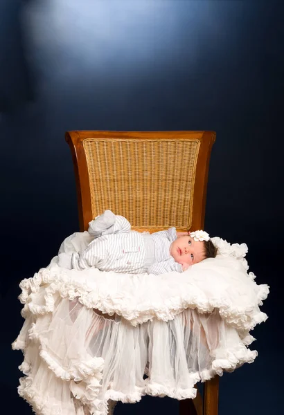 Newborn baby girl with sleeping on a wooden chair — Stock Photo, Image