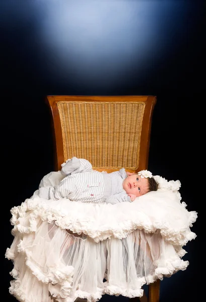 Newborn baby girl with sleeping on a wooden chair — Stock Photo, Image
