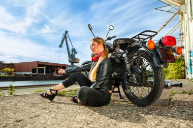 Çekici bir kız dışında poz bir motosiklet üzerinde