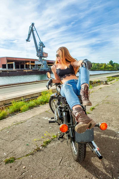 Une jolie fille sur une moto posant à l'extérieur — Photo