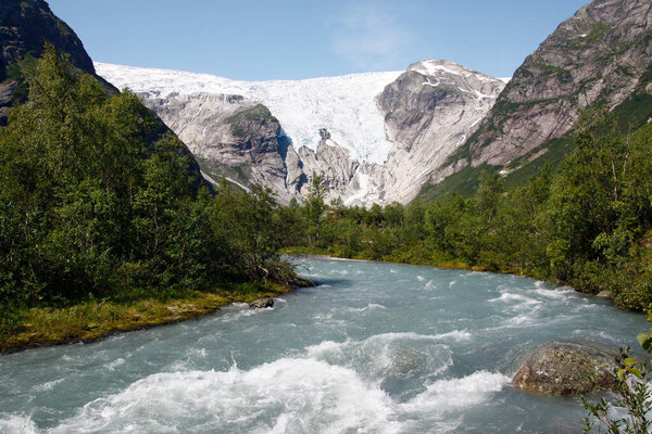 Scenic landscape near the Bergsetbreen glacier in Norway, where rugged mountains, lush valleys, and glacial ice create a breathtaking and pristine natural setting.