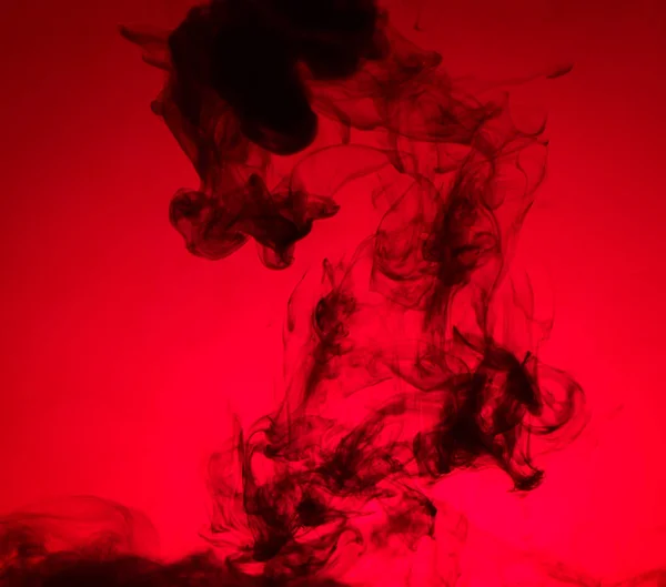 Black smoke on red background — Stock Photo, Image