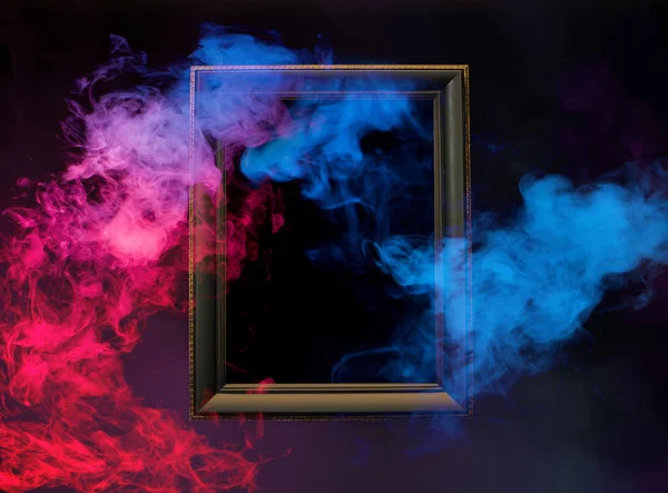 abstract colorful smoke from wooden frame on dark background