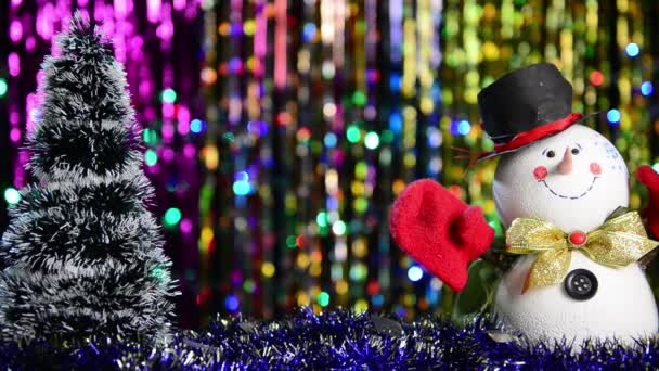Schneemann Und Weihnachtsbaum Mit Fallendem Glänzendem Konfetti Vor Buntem Urlaubshintergrund — Stockvideo
