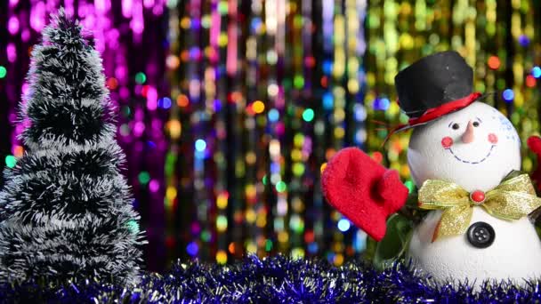 Schneemann Und Weihnachtsbaum Mit Blinkenden Lichtern Vor Buntem Urlaubshintergrund — Stockvideo