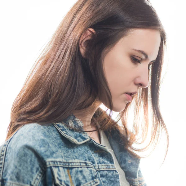 若いシャイ ブルネットの女性の肖像 白い背景に隔離されたジーンズジャケット — ストック写真
