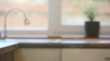 Sabah mutfağı boyunca ağır çekim. Pencere manzaralı ve masada çay.