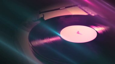 Renkli ışık arkaplanından başlayarak raylarda iğne bulunan vinil plaka üzerinde dönen vinil çalar