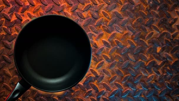 色彩斑斓的金属背景上的黑色烤锅着火了 — 图库视频影像