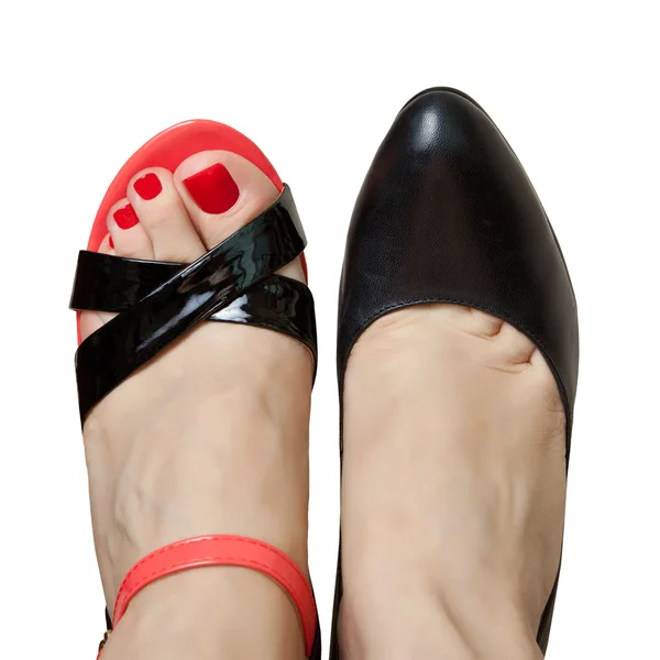 Paar benen van de vrouw in verschillende schoenen — Stockfoto