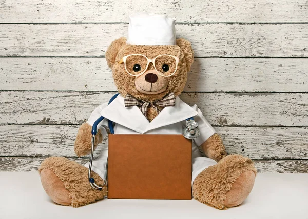Teddy urso-médico com um livro — Fotografia de Stock