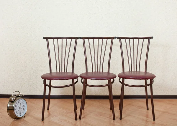 Drie van dezelfde stoel tegen de muur naast het alarm — Stockfoto