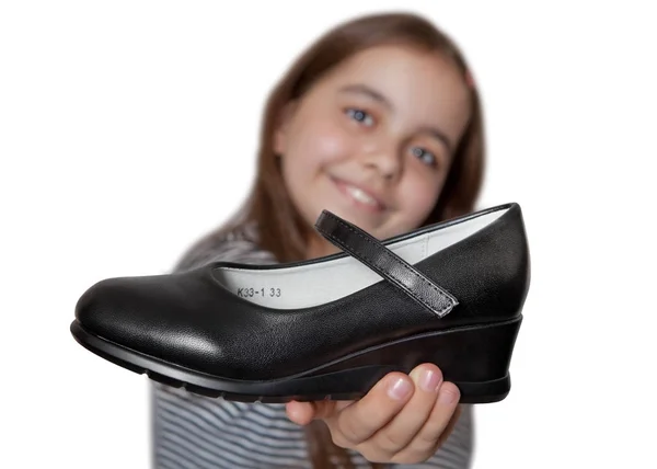 Cheerful girl holding in hand in front of a black Shoe — Stock Photo, Image