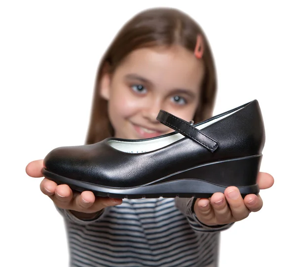 Happy girl holding in hand in front of a black Shoe — Stock Photo, Image