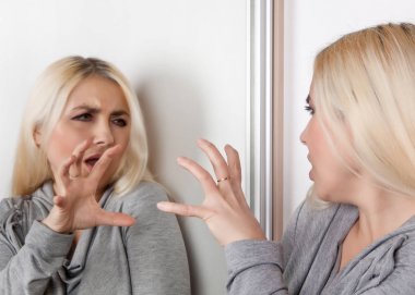 Saldırgan kadın kendi kendine aynada söz. 