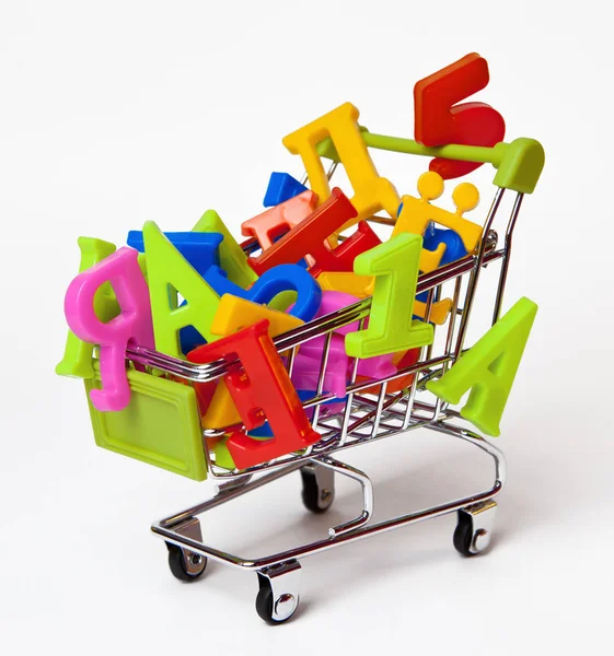 Russian multi-colored magnetic letters and numbers in the small grocery cart . Royalty Free Stock Photos