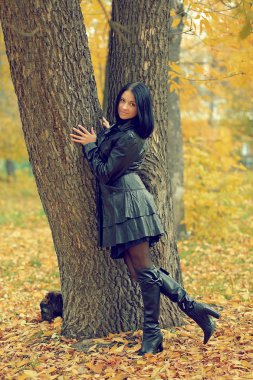 Sonbahar Park deri giysili güzel genç esmer