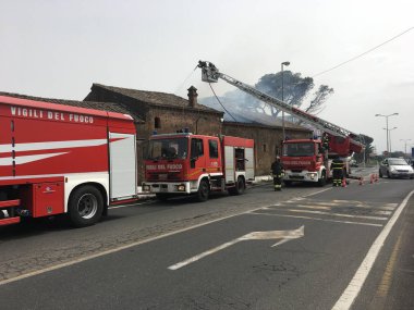 İtfaiyeciler bir eski evinde bir yangın söndürmek için meşgul