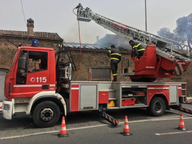 İtfaiyeciler bir eski evinde bir yangın söndürmek için meşgul