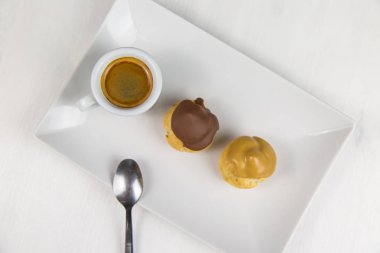 bigne' ve beyaz çanak üzerinde kahve