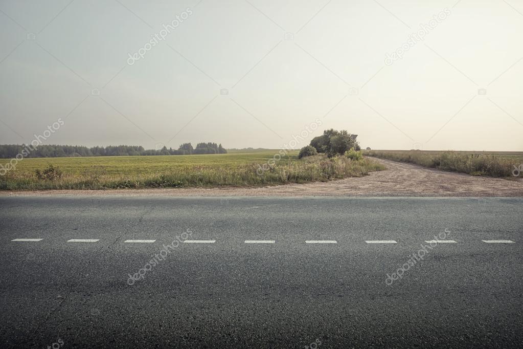 asphalt road through the green field