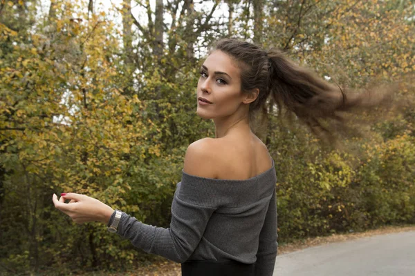 Sonbahar ormandaki at kuyruğu ile güzel kız