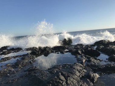 Okyanus dalgaları, sonbaharlar, fırtınada kayalık bir sahil.
