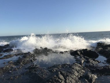 Okyanus dalgaları, sonbaharlar, fırtınada kayalık bir sahil.
