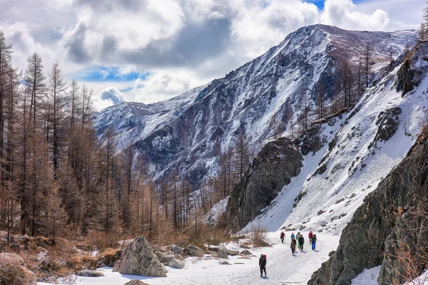 MUNCH-SARDYK, BURYATIA, RUSIA - 30 de abril de 2016: Grupo de escaladores va por el canal del río congelado en las montañas —  Fotos de Stock