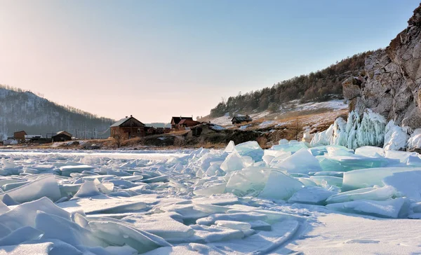 Hummocks van het ijs op het Baikalmeer in de buurt van een klein dorpje Stockfoto