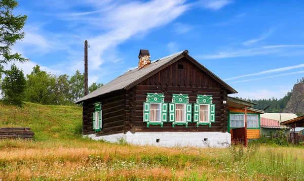 BOLSHIYE KOTY, REGIÓN IRKUTSK, RUSIA - 24 de julio de 2017: Cabaña rusa de madera con persianas verdes en las ventanas —  Fotos de Stock