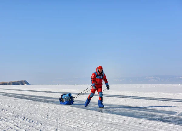 LAKE BAIKAL, IRKUTSK REGION, RUSSIA - March 08, 2017: Man in an orange polar overalls is skating — Stock Photo, Image