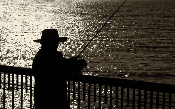 Pescatore da solo su un molo — Foto Stock