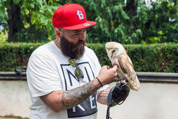 Bearded hipster with an owl in his hand