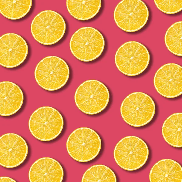 Візерунок шматочків лимона на яскравому кольоровому фоні граната — стокове фото