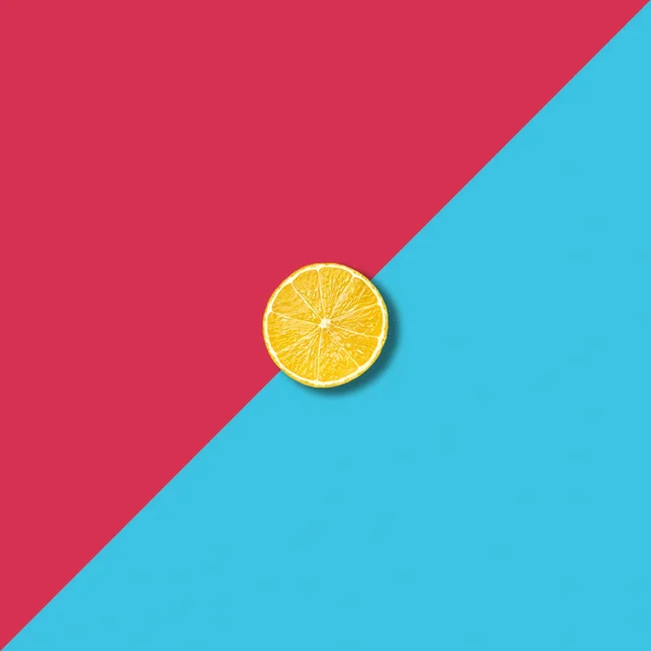 Minimaliste abstrait avec une seule tranche de citron sur fond coloré vibrant — Photo