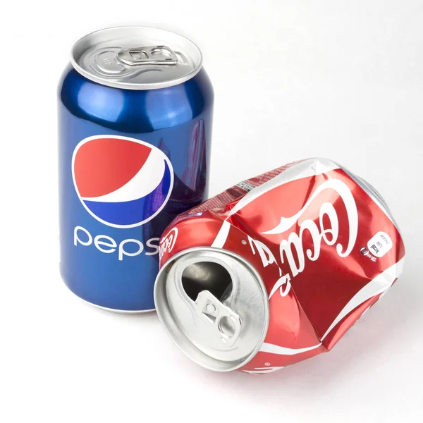 Concepto de competición corporativa con latas Pepsi y Coca-cola aisladas en blanco Fotos De Stock Sin Royalties Gratis