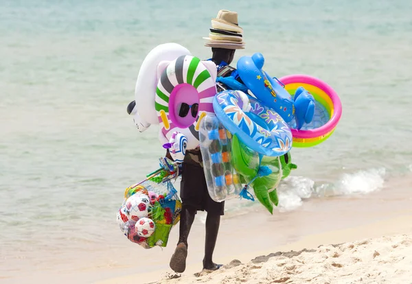 イタリアのサンタ マルゲリータ 2016年7月5日 暑い夏の日にビーチを歩く黒人失業者の写真とイタリアのサルデーニャ島のサンタ マルゲリータ プラのおもちゃやビーチ用品を販売しています — ストック写真