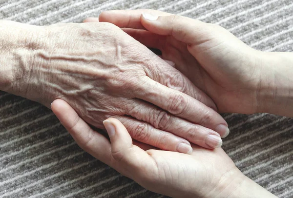 Młode Dłonie Trzymające Starą Kobietę Rękę Zbliżenie — Zdjęcie stockowe