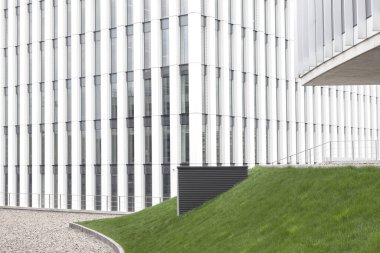 Modern mimari binası, iş merkezinin beyaz dış görünüşü, ofis inşaatı detayları.