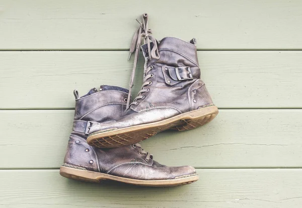 Par Velhos Sapatos Couro Desgastados Pendurados Parede Madeira Botas Abandonadas — Fotografia de Stock