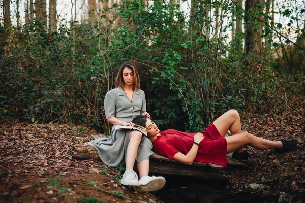Młode kobiety czytające książkę i robiące zdjęcia w lesie — Zdjęcie stockowe