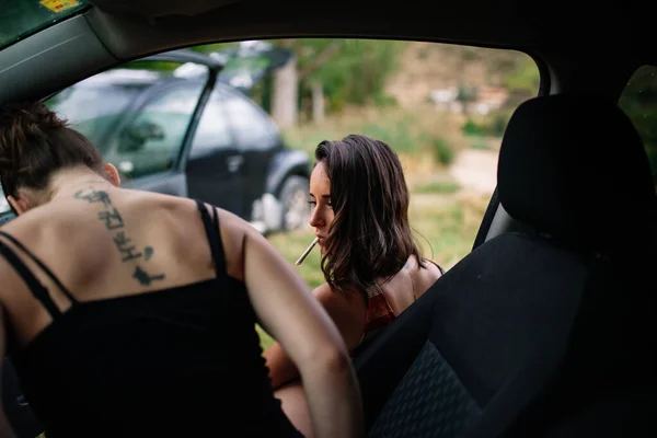 Due giovani lesbiche fumano dentro una macchina — Foto Stock