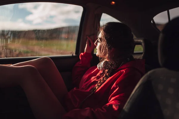 Giovane donna si rifugia dentro una macchina mentre piove — Foto Stock