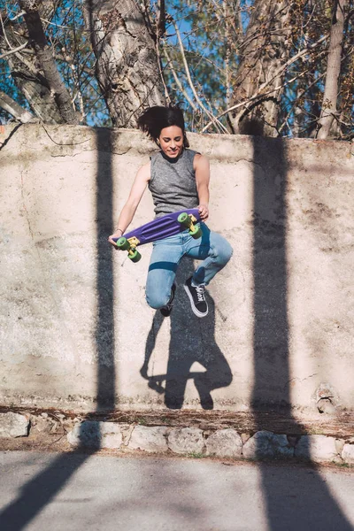 Un skateboarder adolescent fait un vieux truc avec un penny skate — Photo